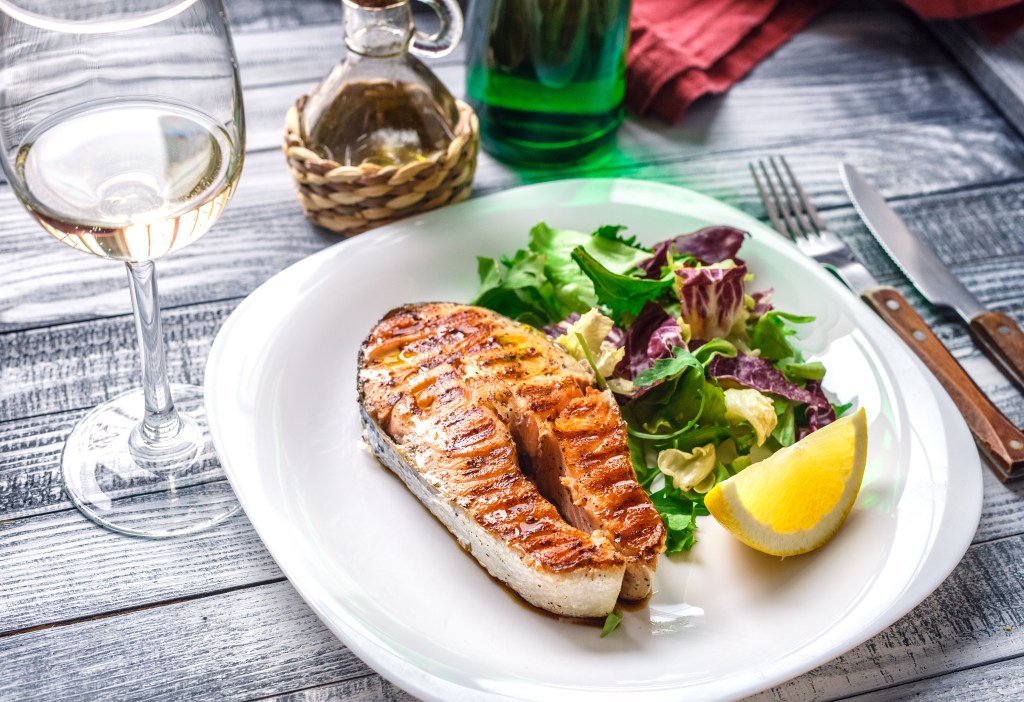 plate of fish with glass of white wine