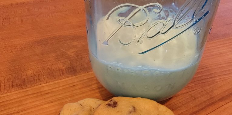 two chocolate chip cookies with milk
