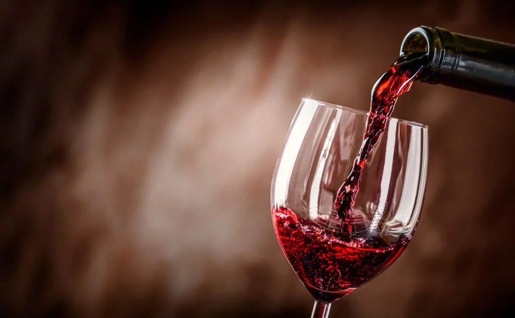 pouring red win into glass