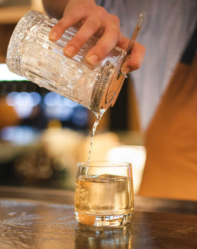 mixologist pouring a drink