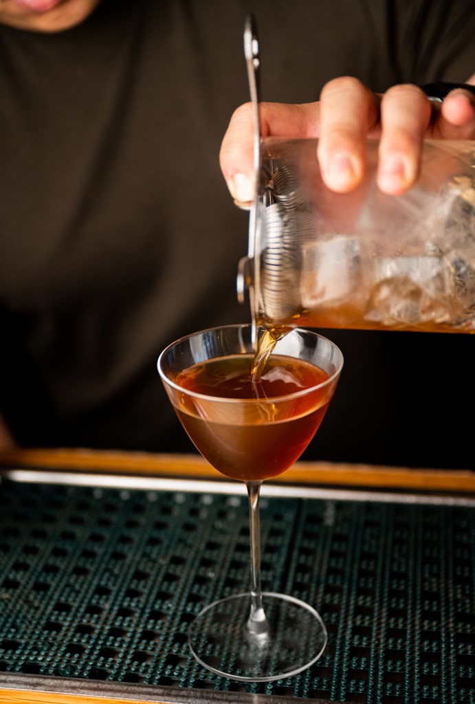 cocktail being poured into glass